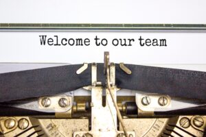 Welcome to our team typed on a typewriter as a welcome to onboarding new team members