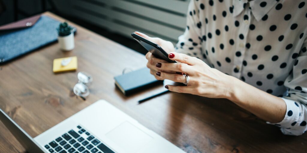 Woman,Working,With,Laptop,And,Mobile,Phone,In,Hands,At