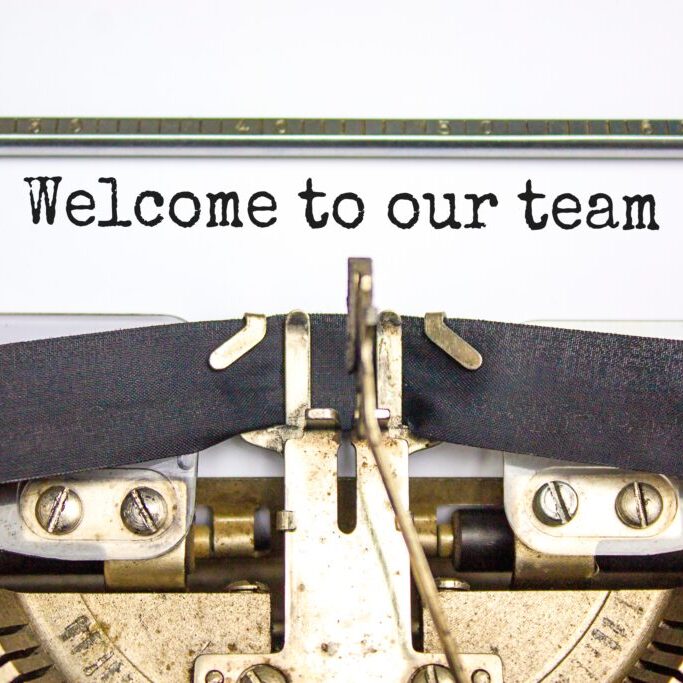 Welcome to our team typed on a typewriter as a welcome to onboarding new team members